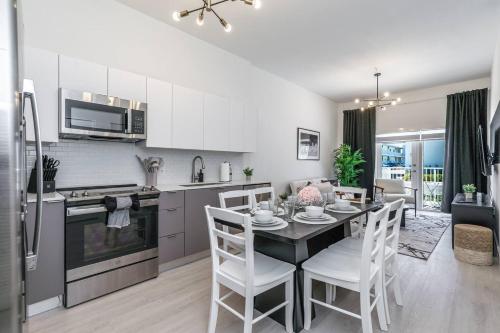 a kitchen and dining room with a table and chairs at Prime 2BR Location Near Miami FIFA World Cup Stadium - Private Parking - EV Station in Hallandale Beach