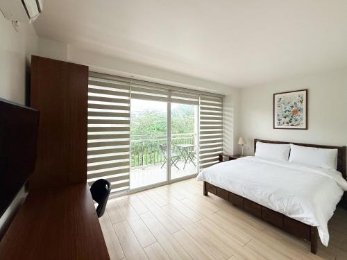 a bedroom with a bed and a large window at The Nest Bed and Breakfast - Kalibo in Kalibo