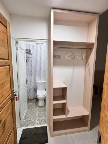 a small bathroom with a toilet and a shower at G-House-2 in Singkawang