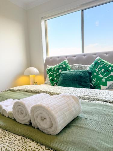 a bedroom with two beds with towels on them at 3-Bedroom Modern Home in Clyde North in Clyde North