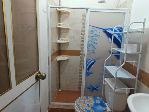 a bathroom with a shower with a blue fish on the wall at Departamento amoblado in Nueva Loja