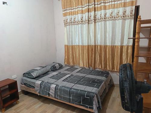 a bedroom with a bed in a room with a curtain at Departamento amoblado in Nueva Loja