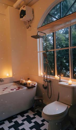 a bathroom with a tub and a toilet and a window at Jin homestay in Thôn Lại Thê