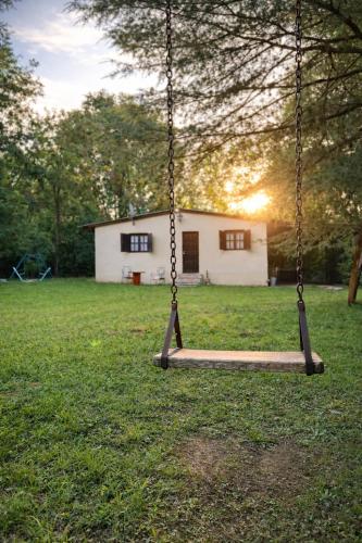 a swing in a yard with a house in the background at El Bosque de Simba - Cabaña in La Estancia