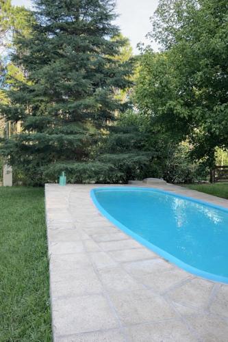 a swimming pool in a yard with a stone walkway at El Bosque de Simba - Cabaña in La Estancia