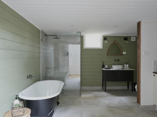 a bathroom with a bath tub and a sink at The Old Trentham Church in Trentham