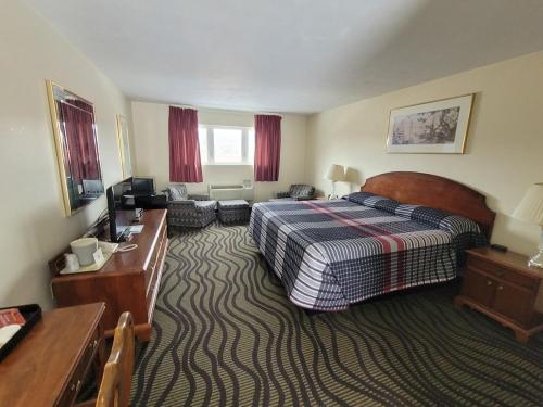 a hotel room with a bed and a desk at The Falls Motel - 2 Mi to " Watkins Glen State Park, Wineries " and 4 Mi to Watkins Glen International Track " The Glen " in Watkins Glen