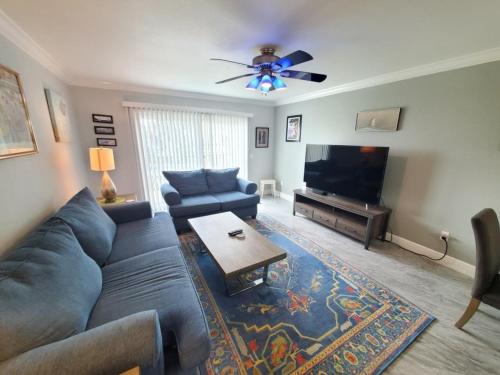 a living room with a blue couch and a flat screen tv at Summerhouse 218 condo in St. Augustine