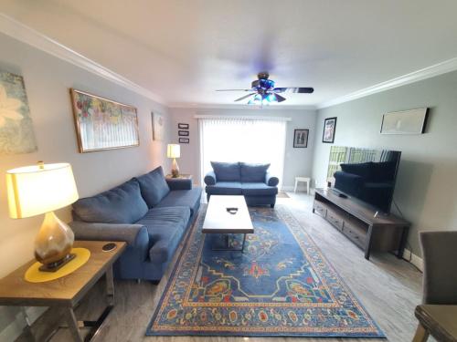 a living room with a blue couch and a television at Summerhouse 218 condo in St. Augustine