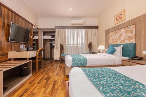 a hotel room with two beds and a flat screen tv at Hotel Arts Kathmandu in Kathmandu
