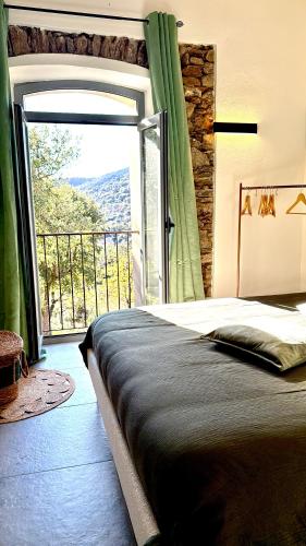 a bedroom with a bed and a large sliding glass door at Demeure de charme, appartement du Campu di l altru mondu in San-Giuliano
