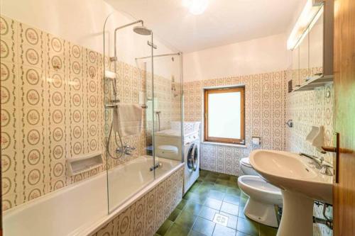 a bathroom with two toilets and a sink and a shower at Casa Mirabella in Sottoguda