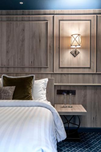 a bedroom with a bed and a table with a lamp at The Coach Hotel Sukhumvit - Asok BTS Bangkok in Bangkok