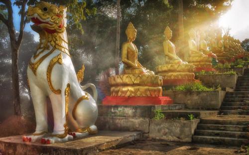 a group of statues sitting on steps in a temple at Kanlaya's Eyrie, Luxury Homestay in Pang Mapha