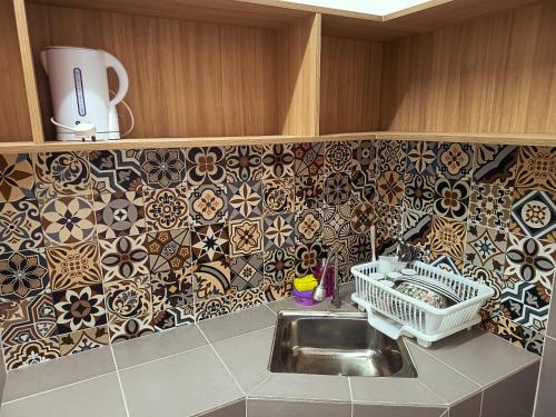 a kitchen with a sink and tiles on the wall at IFS Soho 3 Basic Home in Seri Iskandar