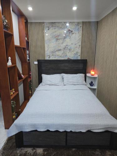 a bedroom with a large bed with a large painting on the wall at Simran's in Glenwood