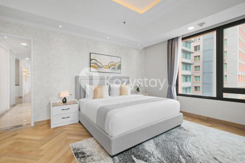a bedroom with a white bed and a large window at Rosen by Kozystay - Thamrin in Jakarta