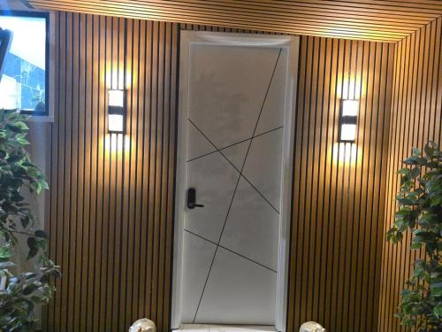 a white door with two lights on a wooden wall at Simran's in Glenwood