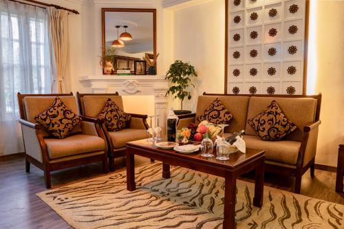 a living room with two couches and a coffee table at Maya Manor Boutique Hotel - A Restored Heritage Mansion in the Heart of Kathmandu in Kathmandu