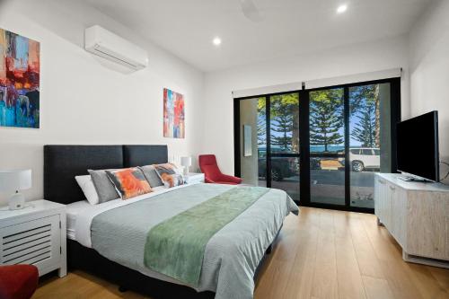 a bedroom with a bed and a flat screen tv at Harborview Modern Apartment 8F in Victor Harbor