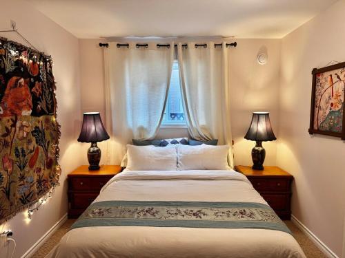 a bedroom with a bed with two lamps and a window at 2BR sweet suite in Nanaimo