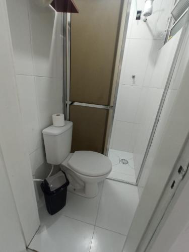 a white bathroom with a toilet and a shower at Apto completo centro in Rio Grande