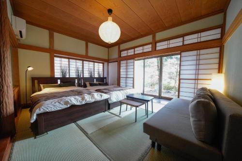a large bedroom with two beds and a couch at Hideaway Hakone Sengokuhara in Sengokuhara