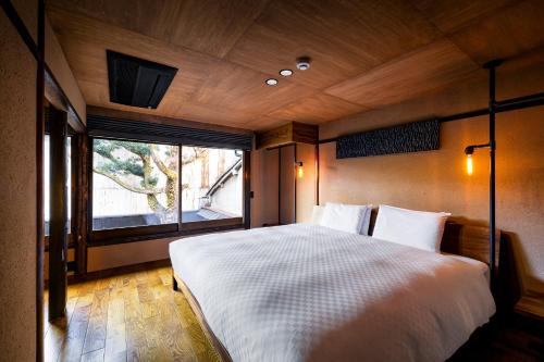 a bedroom with a large bed and a window at Rinn Kyoto Imperial Palace South Kishoan in Kyoto
