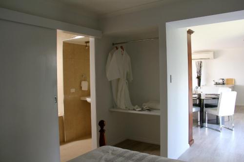 a bedroom with a bathroom with a shower and a table at Lure Bed and Breakfast in Normanville