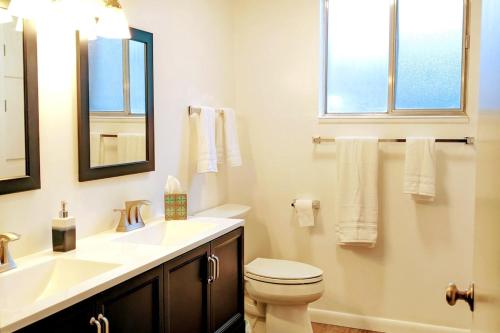 a bathroom with a sink and a toilet and a mirror at The Gate City Grande in Pocatello