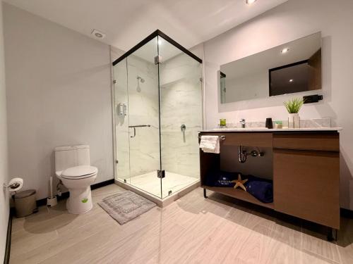 a bathroom with a shower and a toilet and a sink at Departamento Elysian High Country in Guadalajara