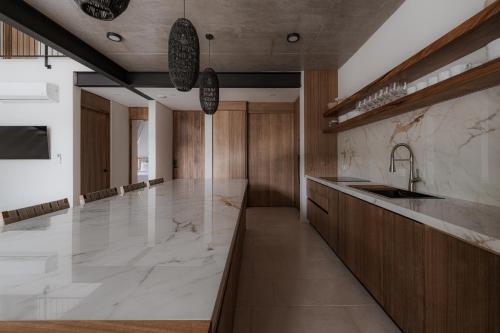 a kitchen with a large marble counter and a sink at The Town at Praia in Jacó