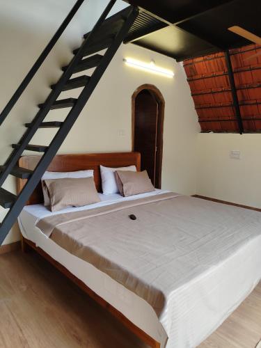 a large bed in a room with a staircase at Arundekar's Cottage in Gokarna