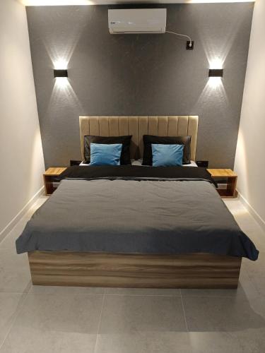 ein Schlafzimmer mit einem großen Bett und blauen Kissen in der Unterkunft Harmony Hideaway Gabala in Qəbələ