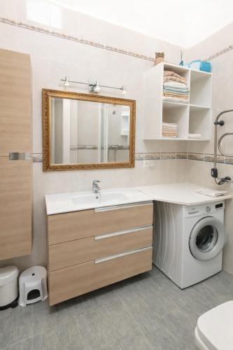 a bathroom with a sink and a washing machine at La casilla de Miguel con jardín privado y piscinas in Denia