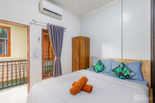 a bedroom with a white bed with orange towels on it at Bali DD homestay seminyak in Seminyak
