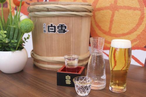 a table with a glass of beer and abeer can at Hiyori Hotel Osaka Shinsekai in Osaka