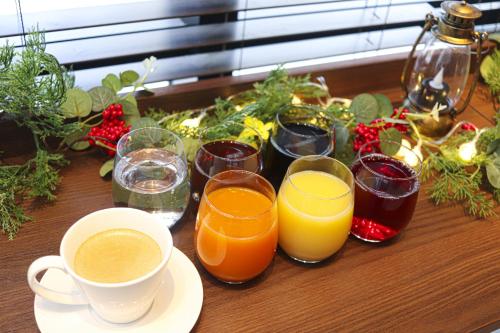 a table with glasses of drinks and a cup of coffee at Hiyori Hotel Osaka Shinsekai in Osaka