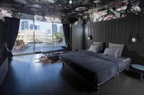 um quarto com uma cama e uma grande janela em Florentin House em Tel Aviv