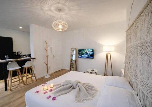 a bedroom with a white bed with candles on it at Spacious & Luxuary Studio in Amiens
