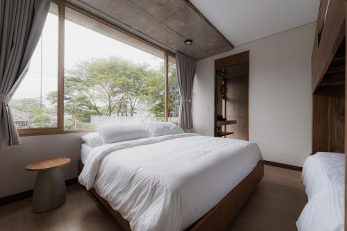 a bedroom with a large bed and a window at The Town at Praia in Jacó