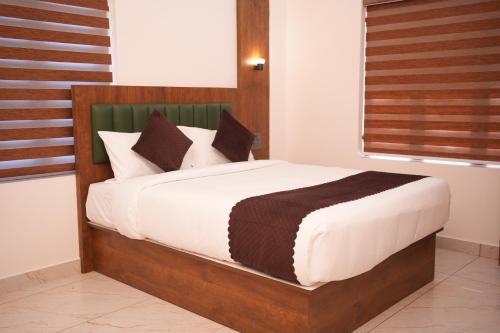 a bedroom with a large bed with a wooden headboard at Pearl Suites in Cochin
