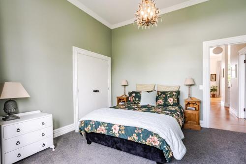 a bedroom with a bed and a chandelier at Britannia Villa in Greytown