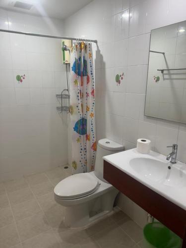 a bathroom with a toilet and a sink and a mirror at Skippers beach guesthouse in Hua Hin