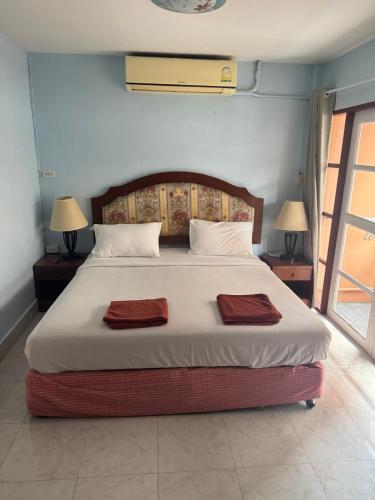 a bedroom with a large bed with two towels on it at Skippers beach guesthouse in Hua Hin