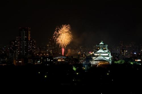 a fireworks display over a city at night at KKR Hotel Osaka in Osaka