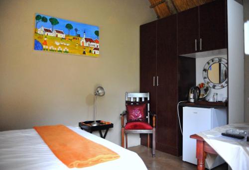 a bedroom with a bed and a table and a chair at Palmwag Tzaneen in Tzaneen