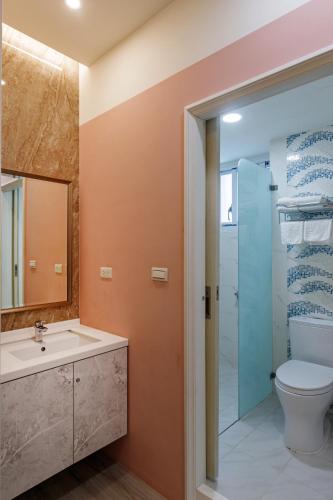 a bathroom with a toilet and a sink and a shower at SMilE WAVE in Xiaoliuqiu