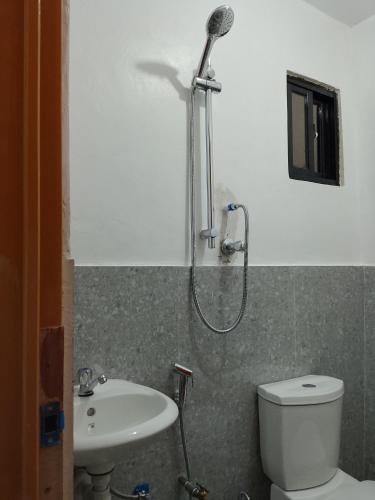 a bathroom with a shower and a toilet and a sink at Mangas Residents in El Nido