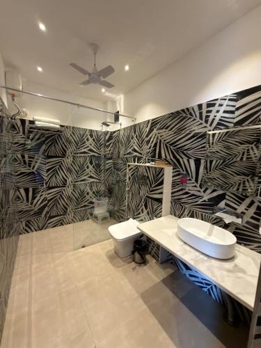 a bathroom with a black and white patterned wall at The Solo House in Jodhpur